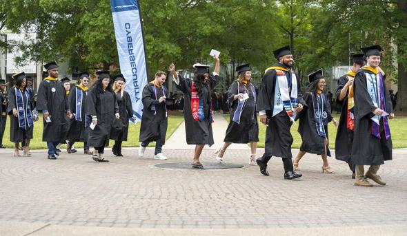 Graduation candidates carry on the tradition of crossing the University seal on their procession to S.B. Ballard Stadium for ODU’s 140th commencement exercises. 